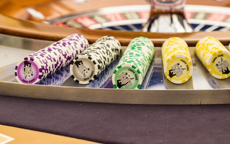 Ruletti ja värikkäät pelimerkkipinot pöydän reunalla