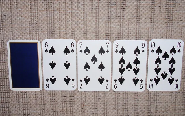 Pokerikäsi pöydällä: yksi kortti kuvapuoli alaspäin ja neljä patakorttia